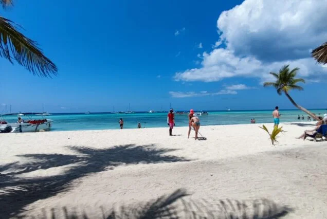 Vista panorámica de la playa de Isla Saona con turistas disfrutando del sol y la arena blanca - tour Isla Saona